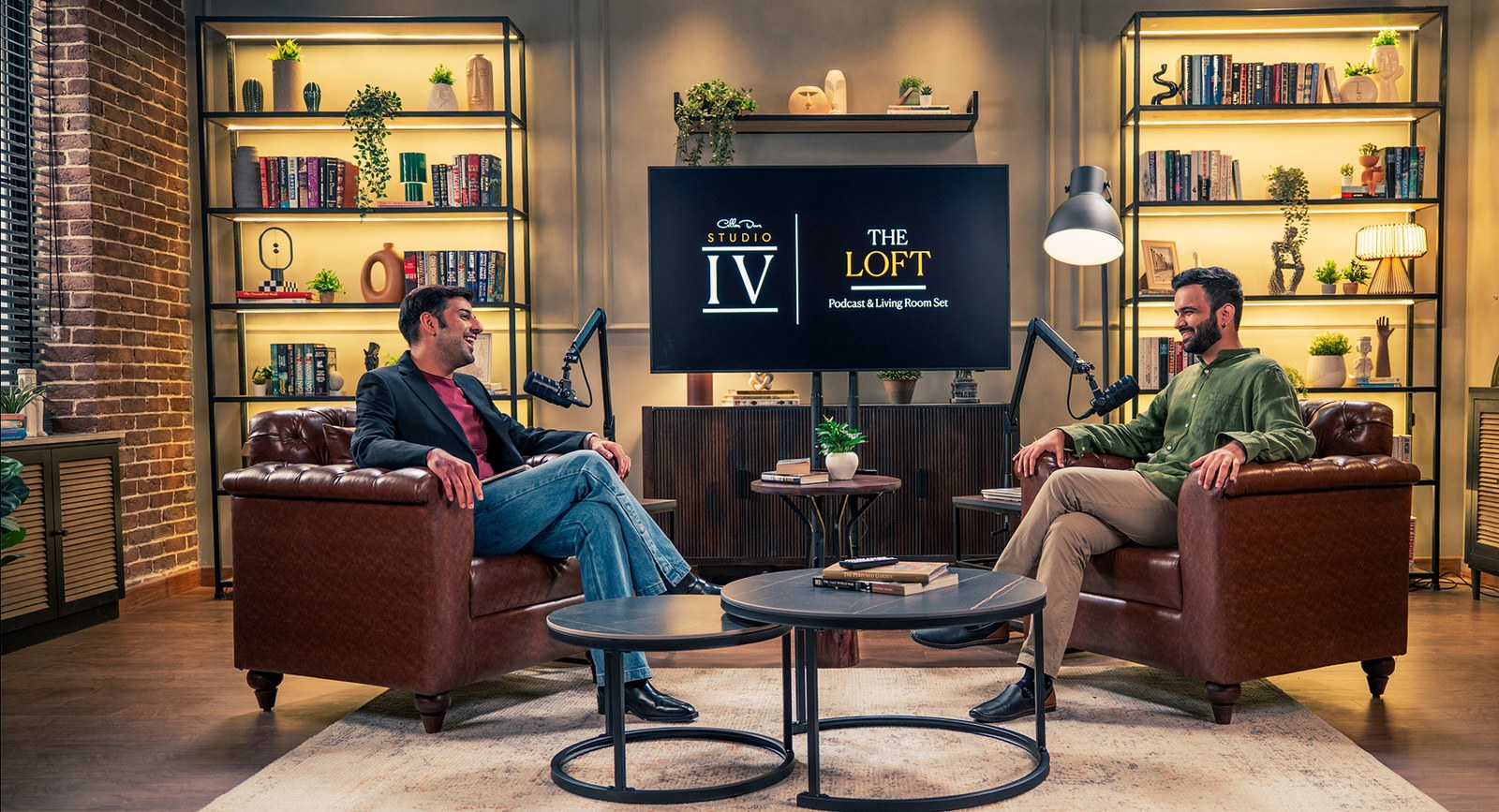 Two-chair podcast setup at The Loft with boom mics and a branded screen